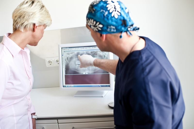 Dr. Knop erklärt einer Patientin das Röntgenbild am Bildschirm