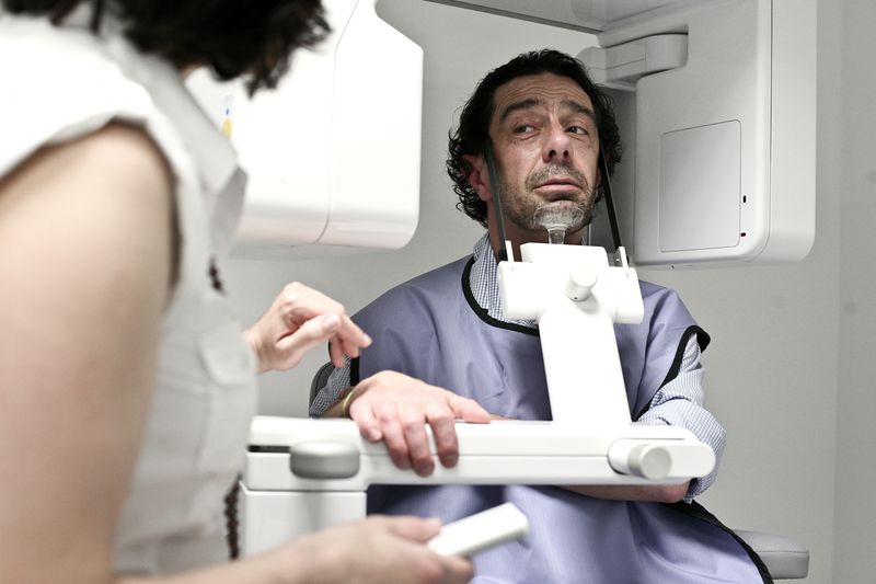 Assistentin richtet einen Patienten am 3D-Volumentomografen aus